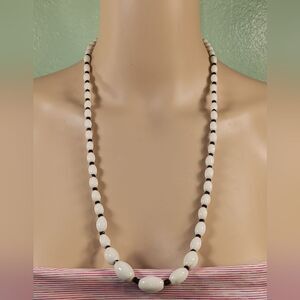 woman white and black necklace